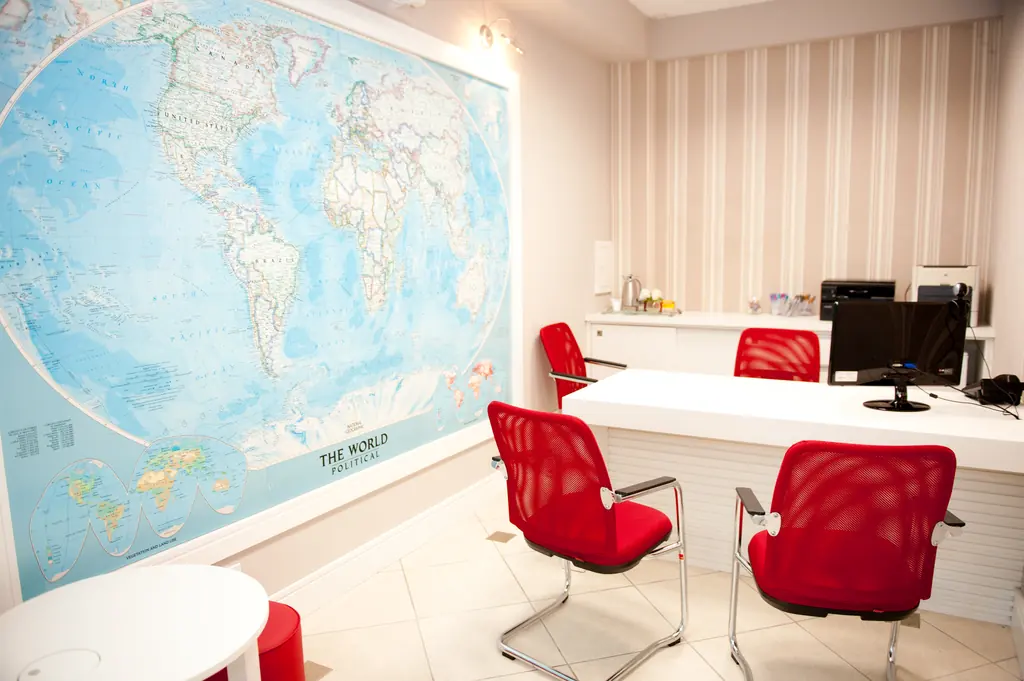 Sala de intercâmbio com mapa-múndi na parede e mesa de atendimento